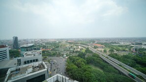 A cityscape with a highway, buildings, and greenery. - Homey 1Br Apartment At Aryaduta Residence Surabaya (Surabaya)