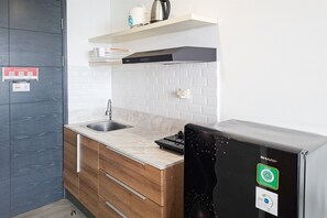 Una cocina moderna con lavavajillas integrado, un refrigerador negro y un armario de madera.