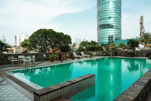 A swimming pool with lounge chairs and a stone wall. - Comfortable 2Br At Semanggi Apartment (Jakarta)