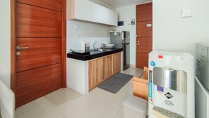Een moderne keuken met houten kastjes, een zwart aanrecht en een roestvrijstalen koelkast.
