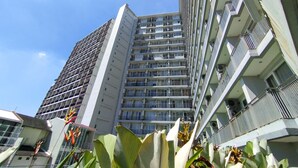 A high-rise building with multiple balconies and a clear sky.