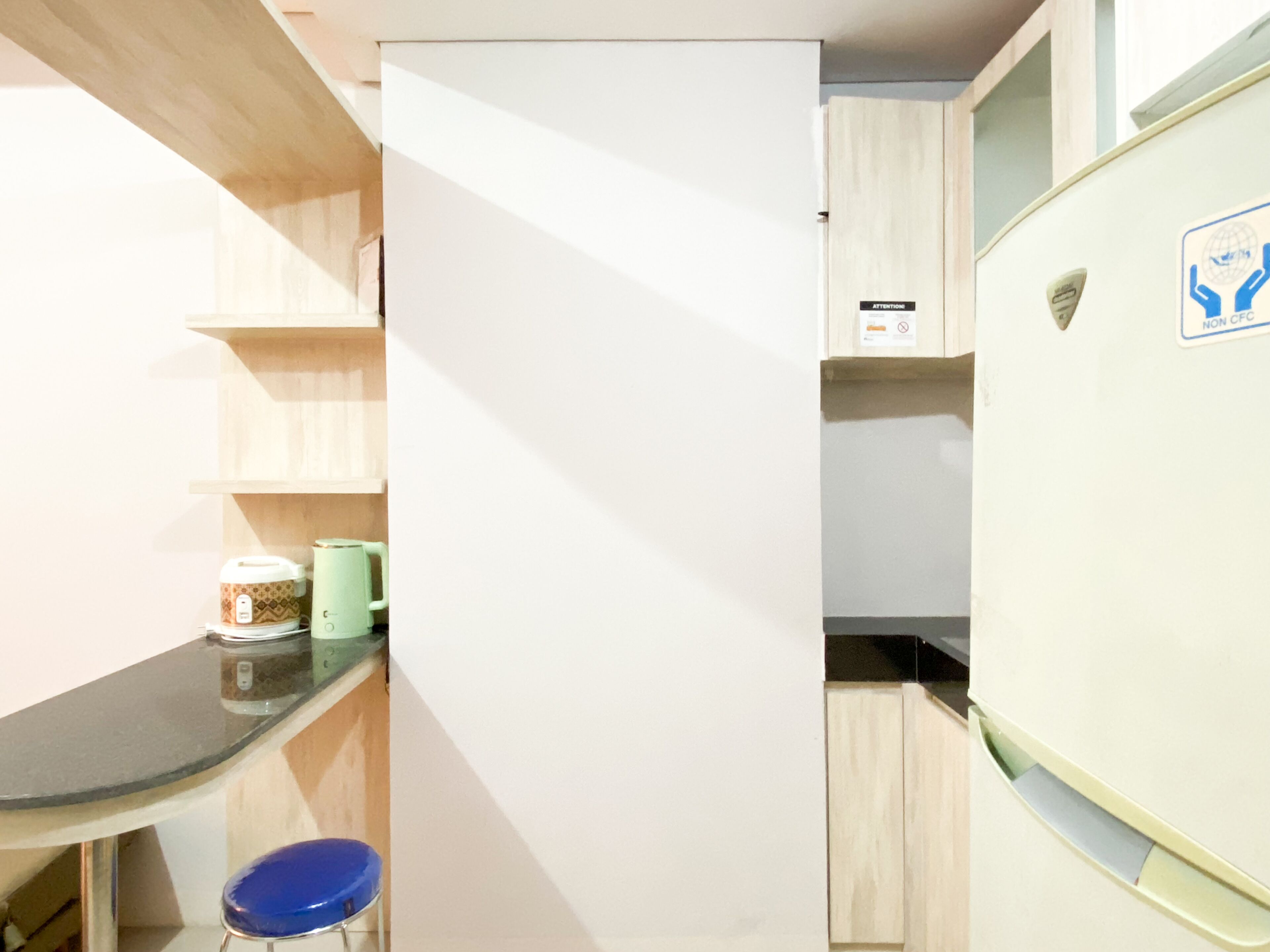 A compact kitchen with a refrigerator, a sink, and a countertop.