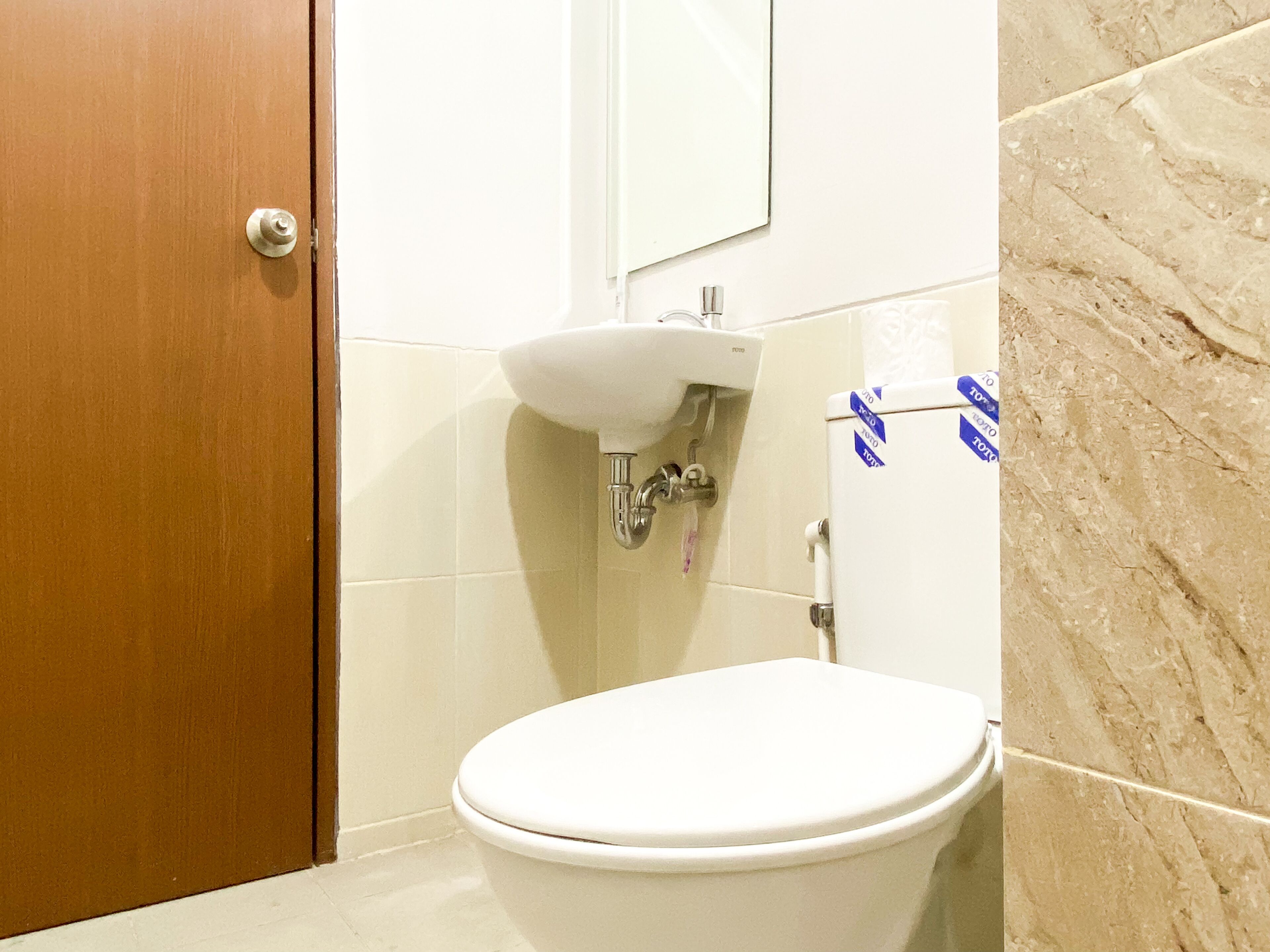 Ein Badezimmer mit Toilette, Waschbecken und Spiegel.