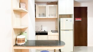 A compact kitchen with a built-in refrigerator, a sink, and a small countertop. - Comfort 2Br At Transpark Juanda Bekasi Timur Apartment (Bekasi)