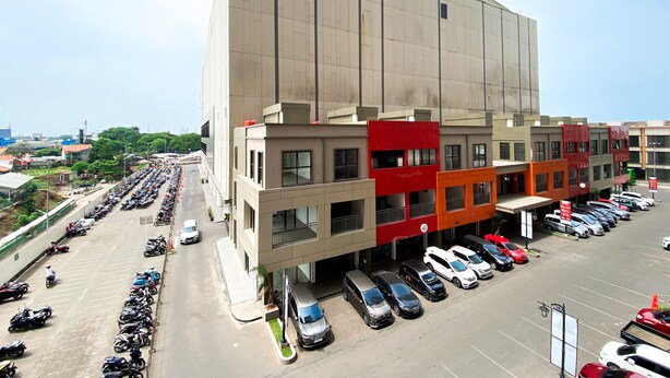 A large building with a parking lot full of cars and motorcycles. - Comfort 2Br At Transpark Juanda Bekasi Timur Apartment (Bekasi)