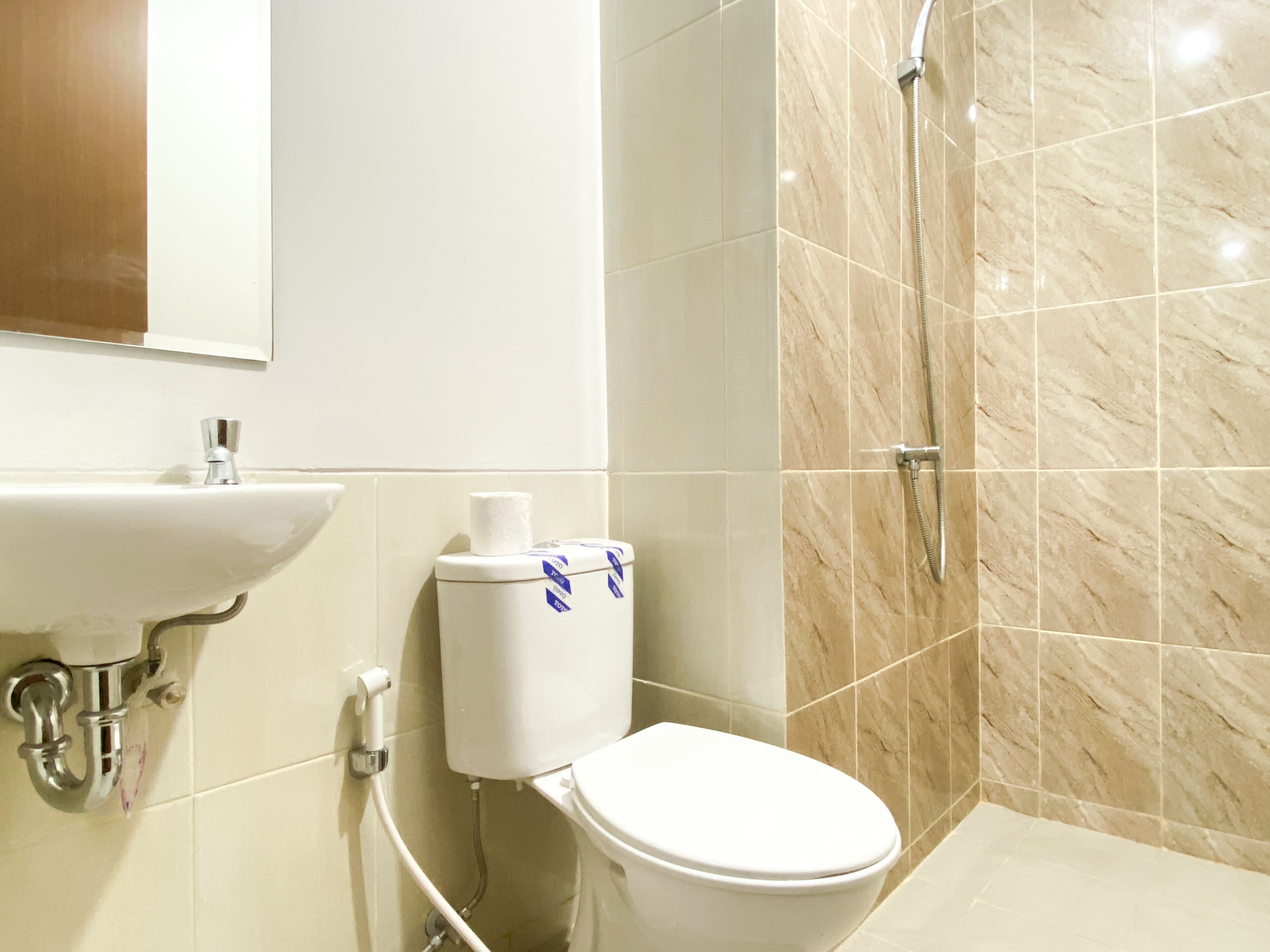A bathroom with a toilet, sink, and shower.