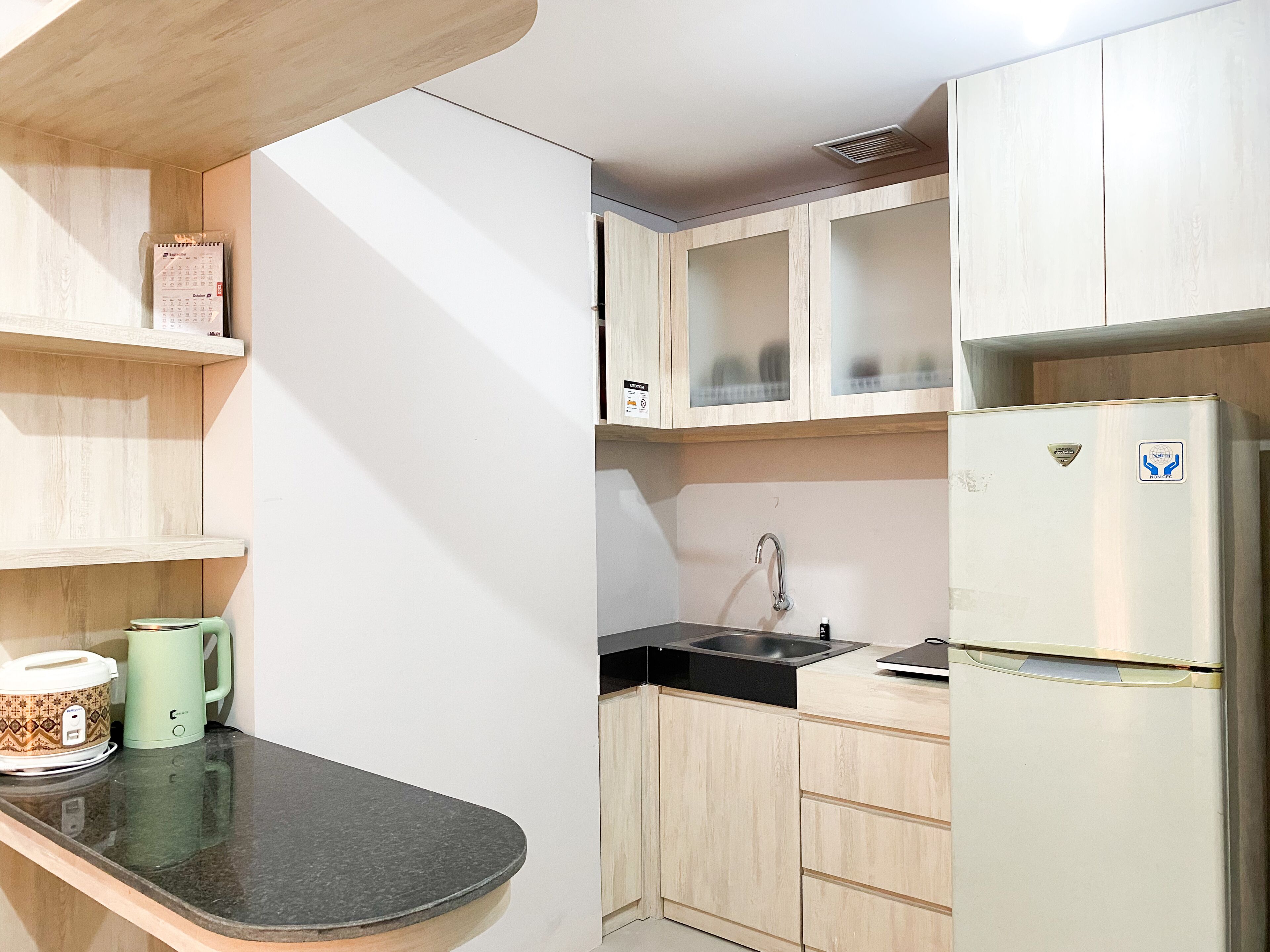 A compact kitchen with a refrigerator, a sink, and a countertop.