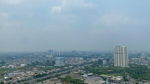 A cityscape with multiple high-rise buildings, a mix of residential and commercial structures, and a clear sky.