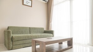 A living room with a green sofa and a wooden coffee table.