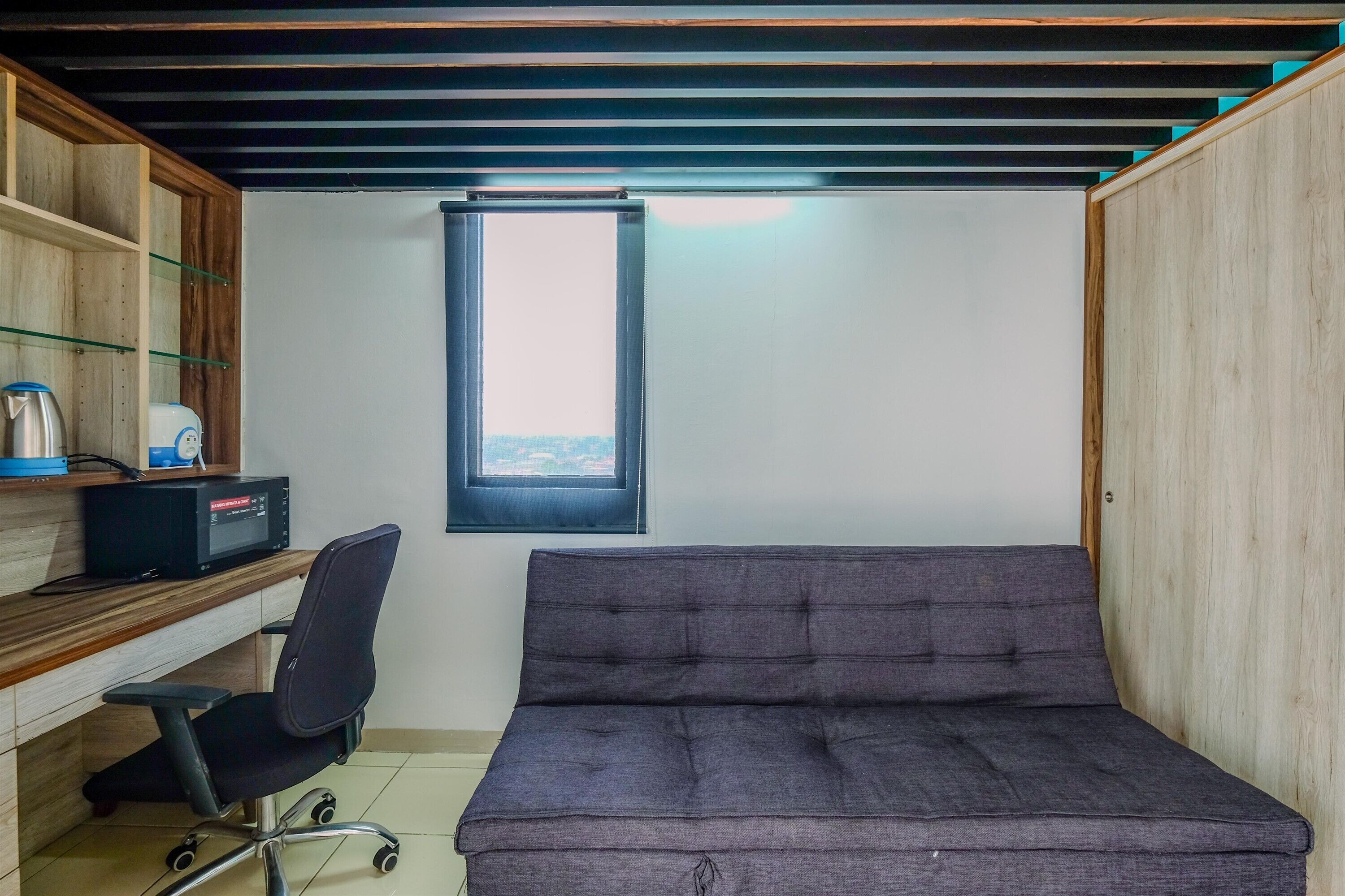 A compact room with a desk, chair, and a bed.