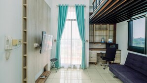 A modern room with a desk, chair, and a sofa. - Best Homey And Cozy Studio At Dave Apartment (Depok)