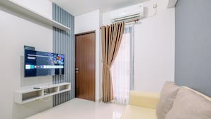 Una sala de estar moderna con un televisor de pantalla plana, un sofá y una puerta corredera.