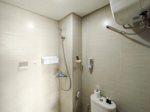 Une petite salle de bain moderne, équipée d’une douche, de toilettes et d’un lavabo.