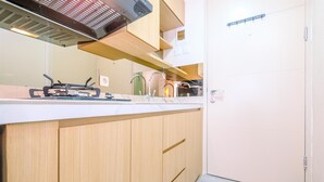Eine Küche mit Holzschränken, einer weißen Arbeitsplatte und einer Edelstahl-Dunstabzugshaube.