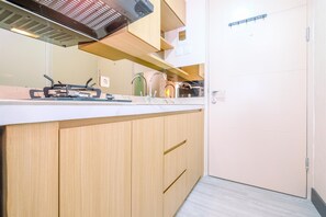 Eine Küche mit Holzschränken, einer weißen Arbeitsplatte und einer Edelstahl-Dunstabzugshaube.