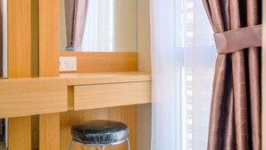 Ein modernes Zimmer mit einem Holztisch, einem schwarzen Hocker und einem Fenster mit durchsichtigen Vorhängen.