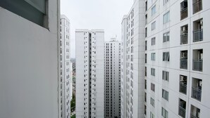 A high-rise residential building with multiple floors, featuring balconies with railings.