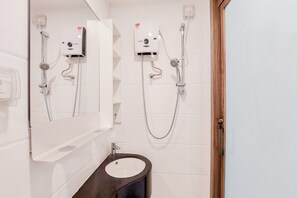 A modern bathroom with a black sink, a mirror, and two wall-mounted shower units. - Stunning And Strategic Studio Apartment Sky House Alam Sutera (Tangerang)