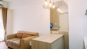 Ein modernes Wohnzimmer mit einem beigen Sofa, einem Holztisch und Pendelleuchten.