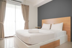 Relax in a serene space with a large bed and convenient side table.
