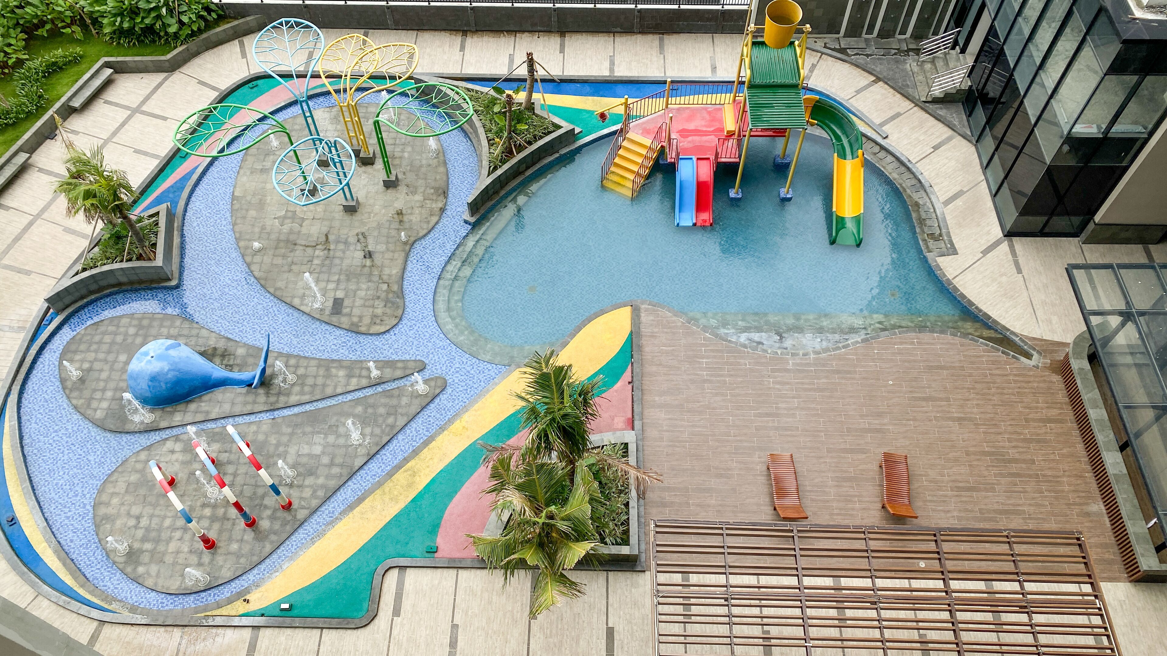 A children's play area with slides, climbing structures, and a pool.