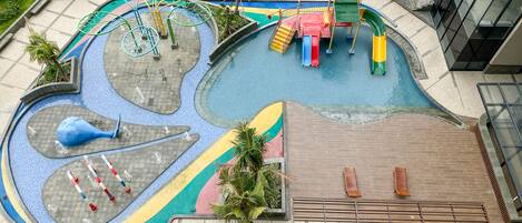 A children's play area with slides, climbing structures, and a pool.
