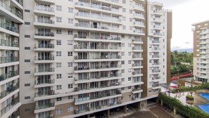 Un immeuble résidentiel de grande hauteur doté de nombreux balcons, d’un espace de stationnement et d’une piscine.
