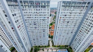 A high-rise residential building with multiple balconies, a central courtyard, and a swimming pool.