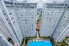 Experience modern urban living with a grid-like facade, a swimming pool, and lush greenery.