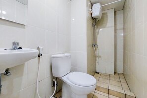 Bathroom features a toilet, sink, and showerhead.