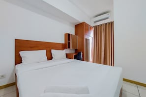 Relax in a spacious room with a large bed, wardrobe, and cozy seating area.