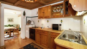 A kitchen with wooden cabinets, a microwave, a stove, and a sink. - Apartment in Längenfeld near Sölden Ski (Längenfeld)