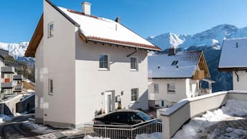 A two-story building with a snow-covered roof and a car parked in front.