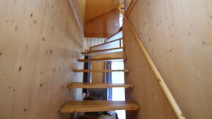 A wooden staircase with a handrail, leading to a landing with windows. - Chalet in Stadl an der Mur near Ski Slopes (Stadl an der mur)