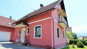 A two-story house with a red exterior, a tiled roof, and a small balcony. - Apartment in Eberndorf near Petzen Ski Area (Eberndorf)