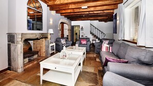 Un salon spacieux doté d’une cheminée, d’un escalier et d’un coin salon confortable.