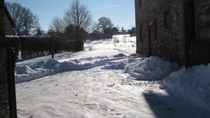 A snow-covered rural road with stone buildings on either side. - Holiday Apartment with Garden in Born (Born (Amel))