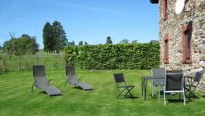 A grassy outdoor area with lounge chairs and a table, likely for outdoor dining or relaxation. - Holiday Apartment with Garden in Born (Born (Amel))