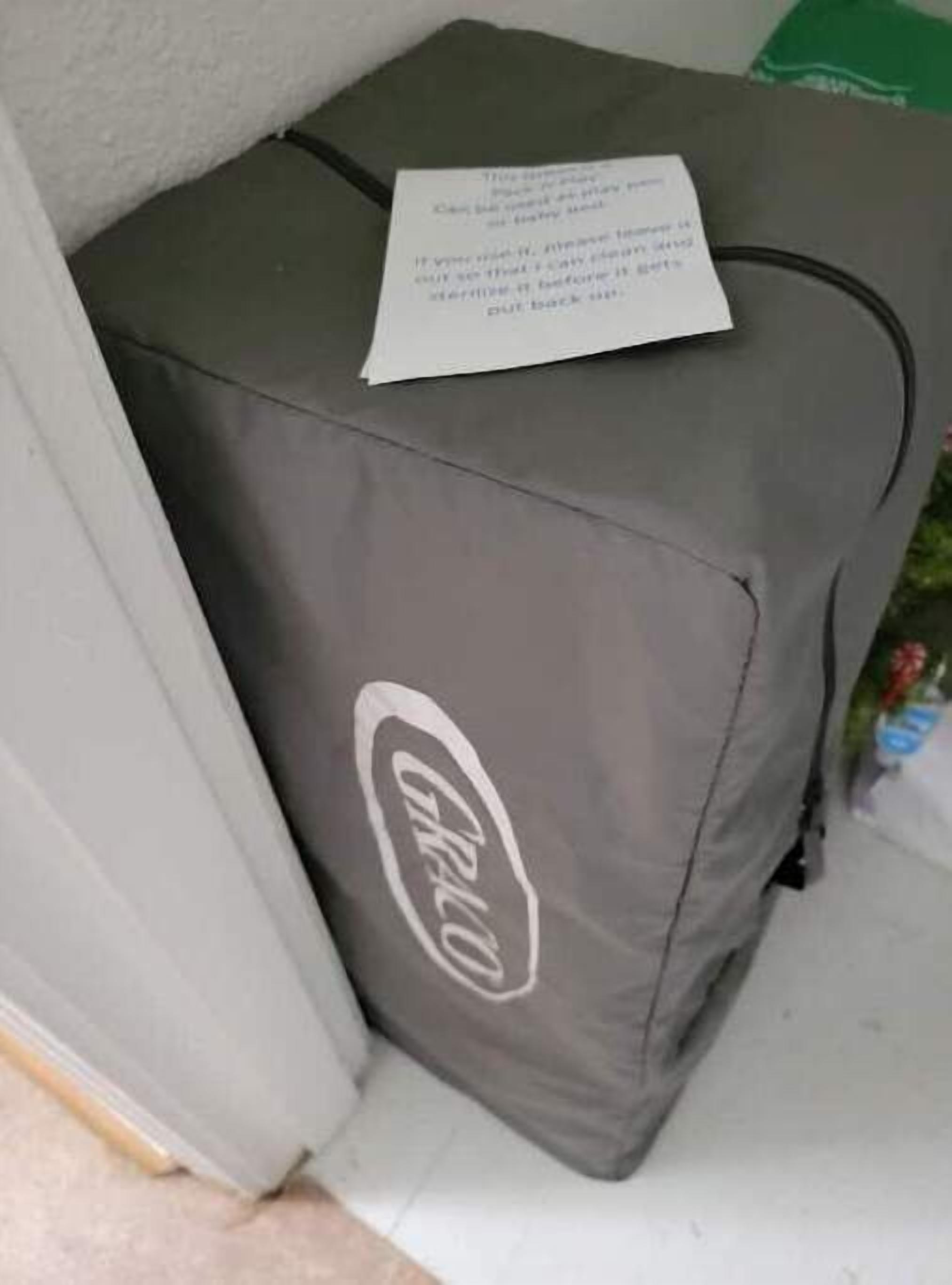 A grey suitcase with a visible logo and a note attached to it.
