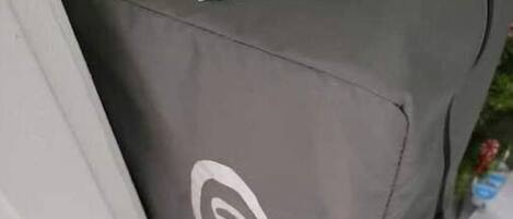 A grey suitcase with a visible logo and a note attached to it.