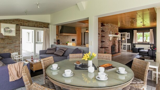 A modern living room with a glass coffee table, comfortable seating, and a brick fireplace. - Rendeux Forest View Retreat (Rendeux-Beffe)