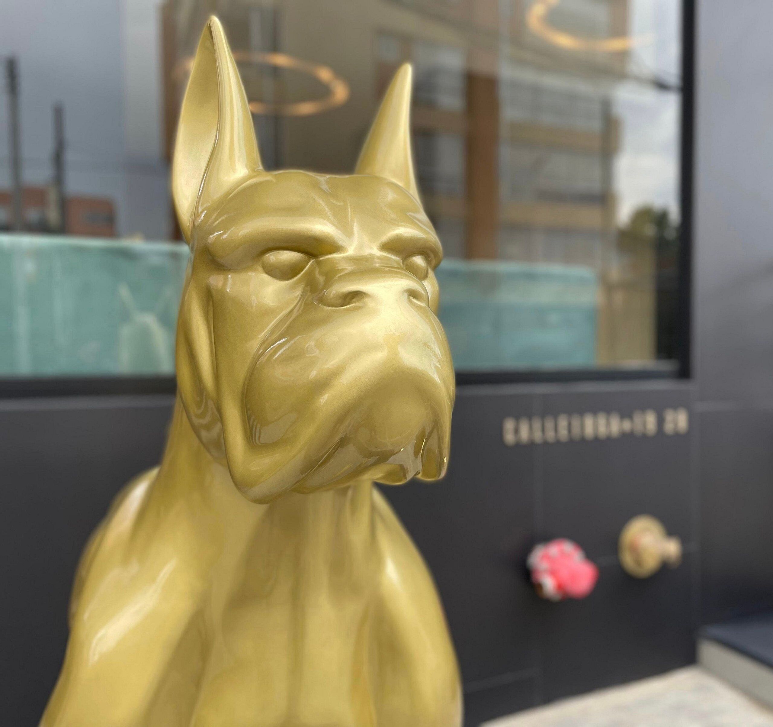 En gylden skulptur af en hund i et moderne interiør.