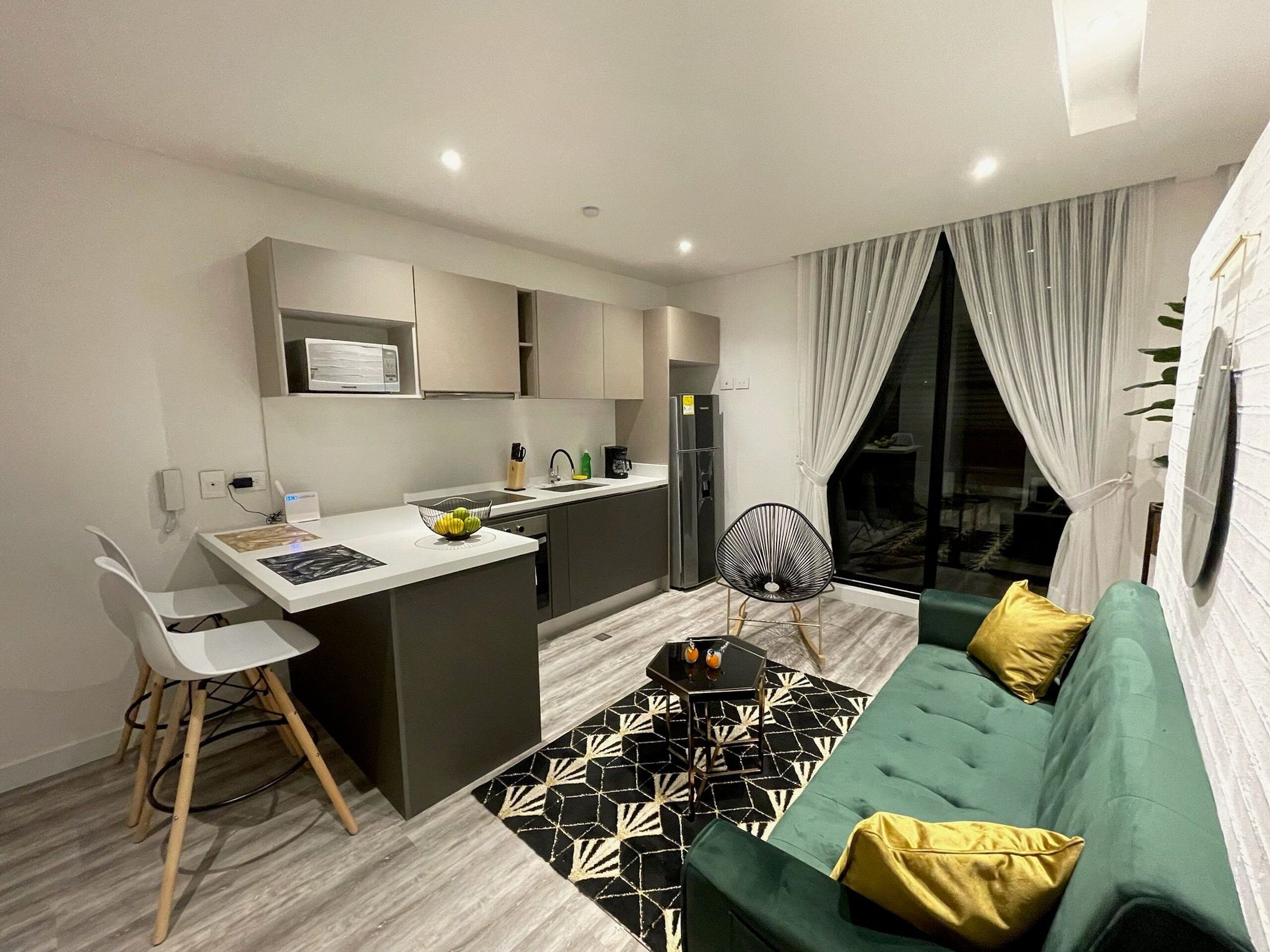 A modern apartment with a kitchen, dining area, and living room.