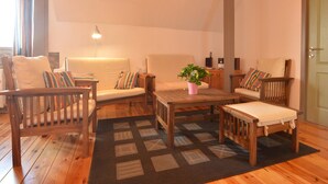 A cozy living room with a sofa, two armchairs, a coffee table, and a lamp. - Holiday Home in Ardennes with Scenic Garden (Halenfeld-Amel)