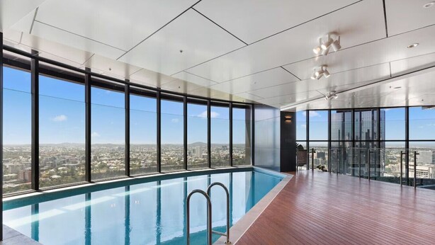 Una piscina interior moderna con amplias ventanas y vista a la ciudad.