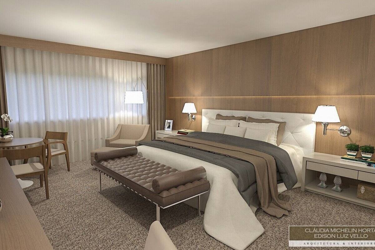 Ein modernes Hotelzimmer mit einem großen Bett, einem Nachttisch, einem Sessel und einem Schreibtisch.
