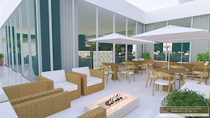 A modern outdoor seating area with wicker furniture and white umbrellas, overlooking a glass building with a patterned interior. - White Plaza Hotel (Curitiba)