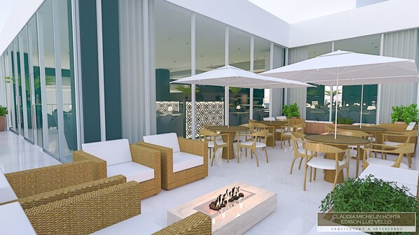 Uma área de estar moderna ao ar livre, com móveis de vime e guarda-sóis brancos, com vista para um edifício de vidro com interior trabalhado.