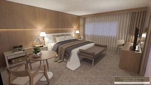 Una habitación de hotel moderna con una cama grande, mesitas de noche con lámparas, una pequeña mesa redonda y un sofá.