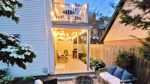 A backyard with a wooden deck, outdoor seating, and a fire pit. - Victorian Village Townhome, large living space in the heart of the short north! (Columbus)